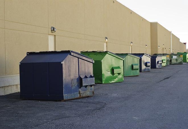 an assortment of sturdy and reliable waste containers near a construction area in Amory